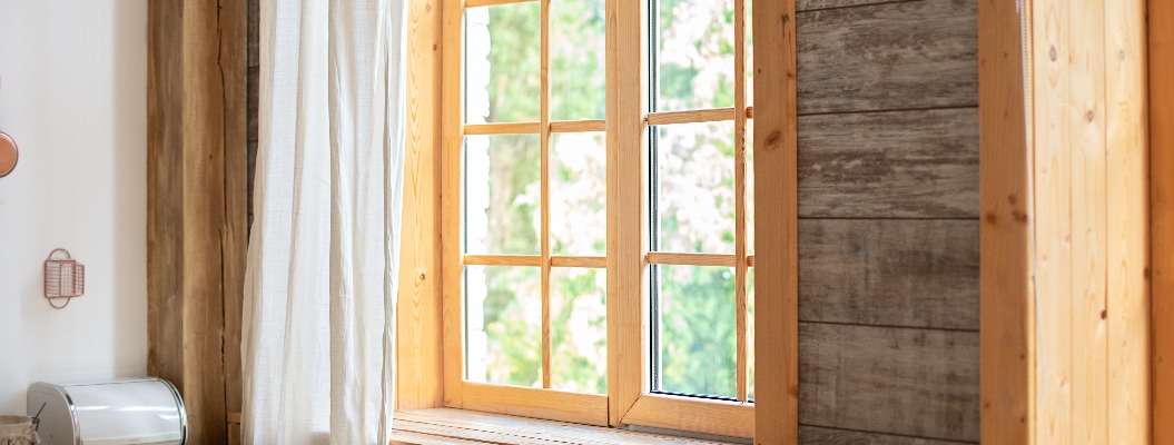Großes Holzfenster mit Rahmen und Fensterbank und Natur auf der Rückseite